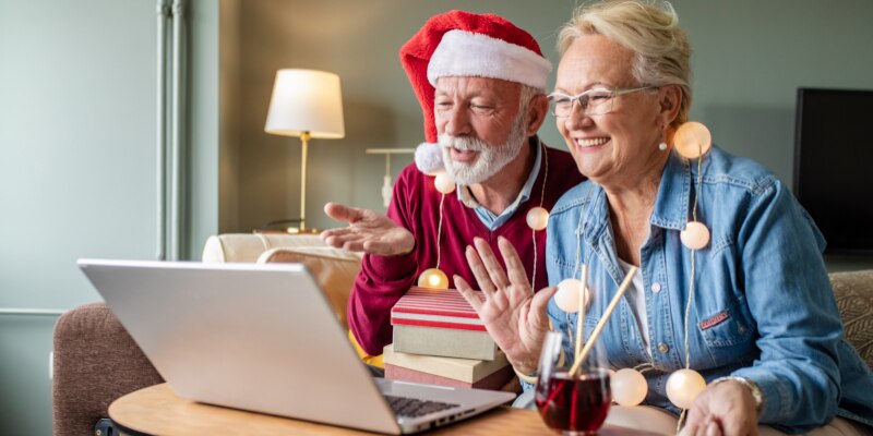 older adults waving to someone on a computer