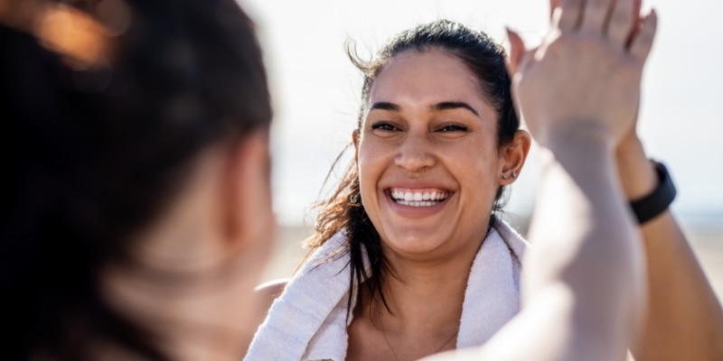 Woman celebrating a fitness goal with a friend