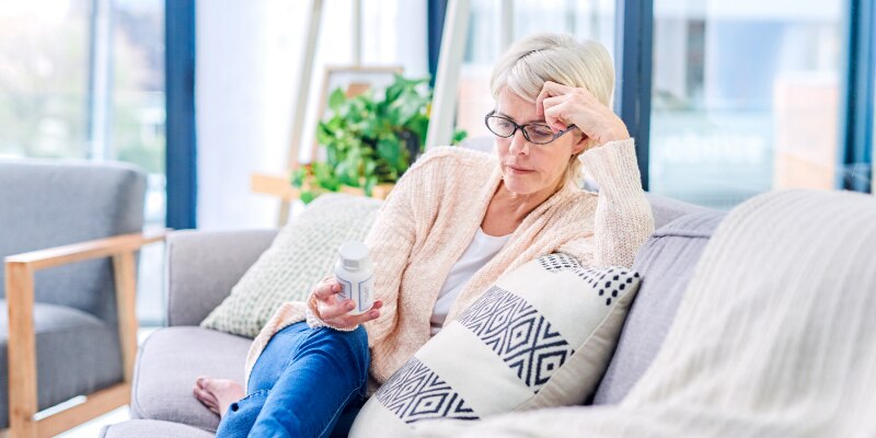 Woman looking at supplement bottle