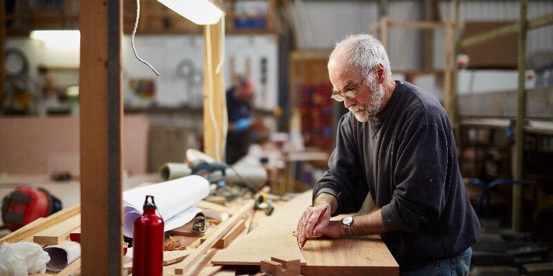 Man measuring a board with glasses on eye health
