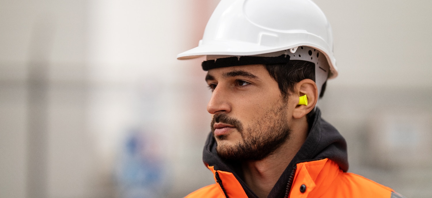 man wearing ear plugs to protect ear health