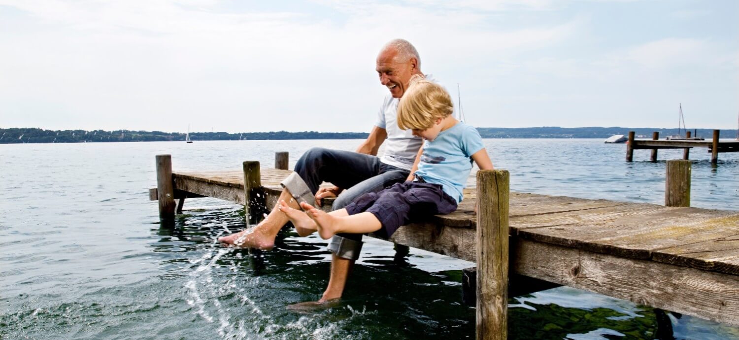 energetic senior adult with grandchild at lake