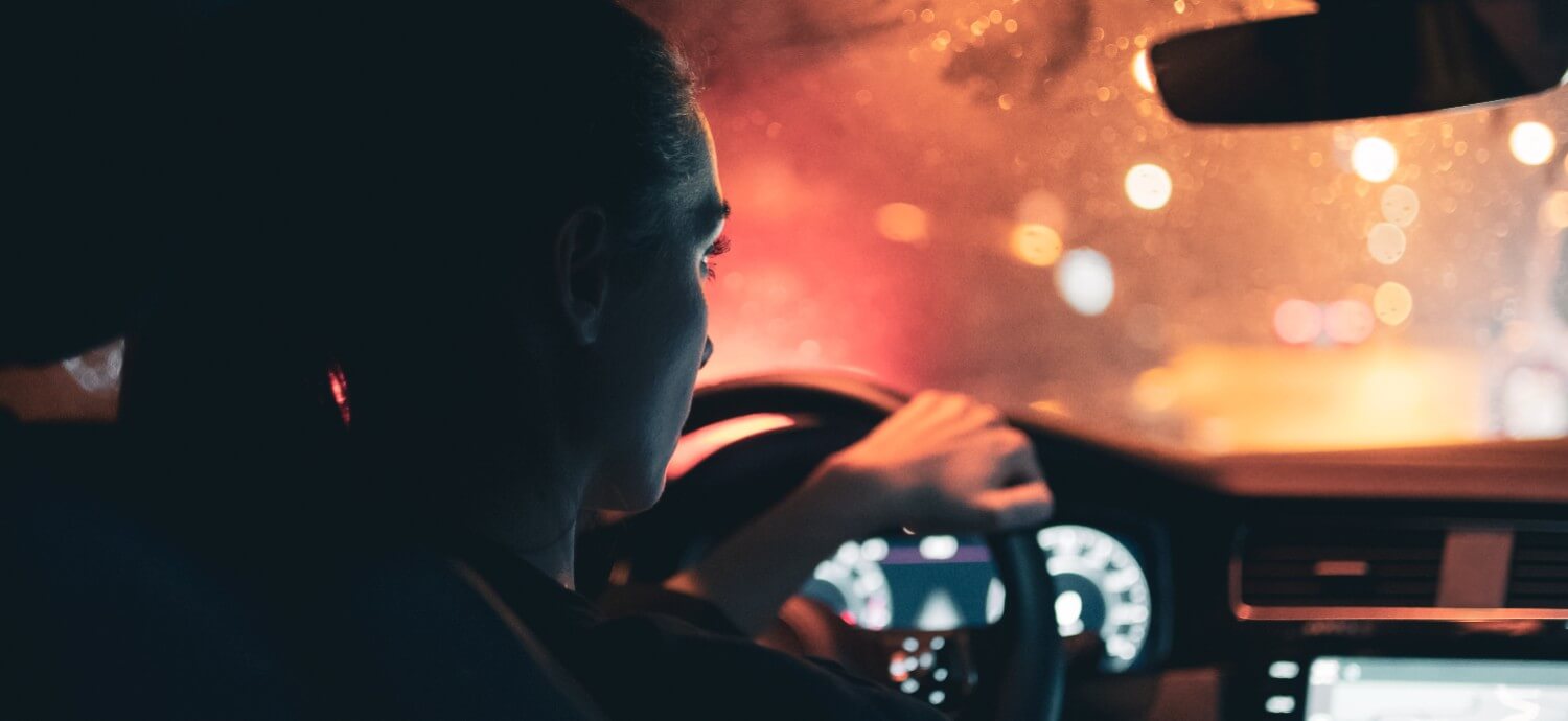 woman driving at night looking out of windshield