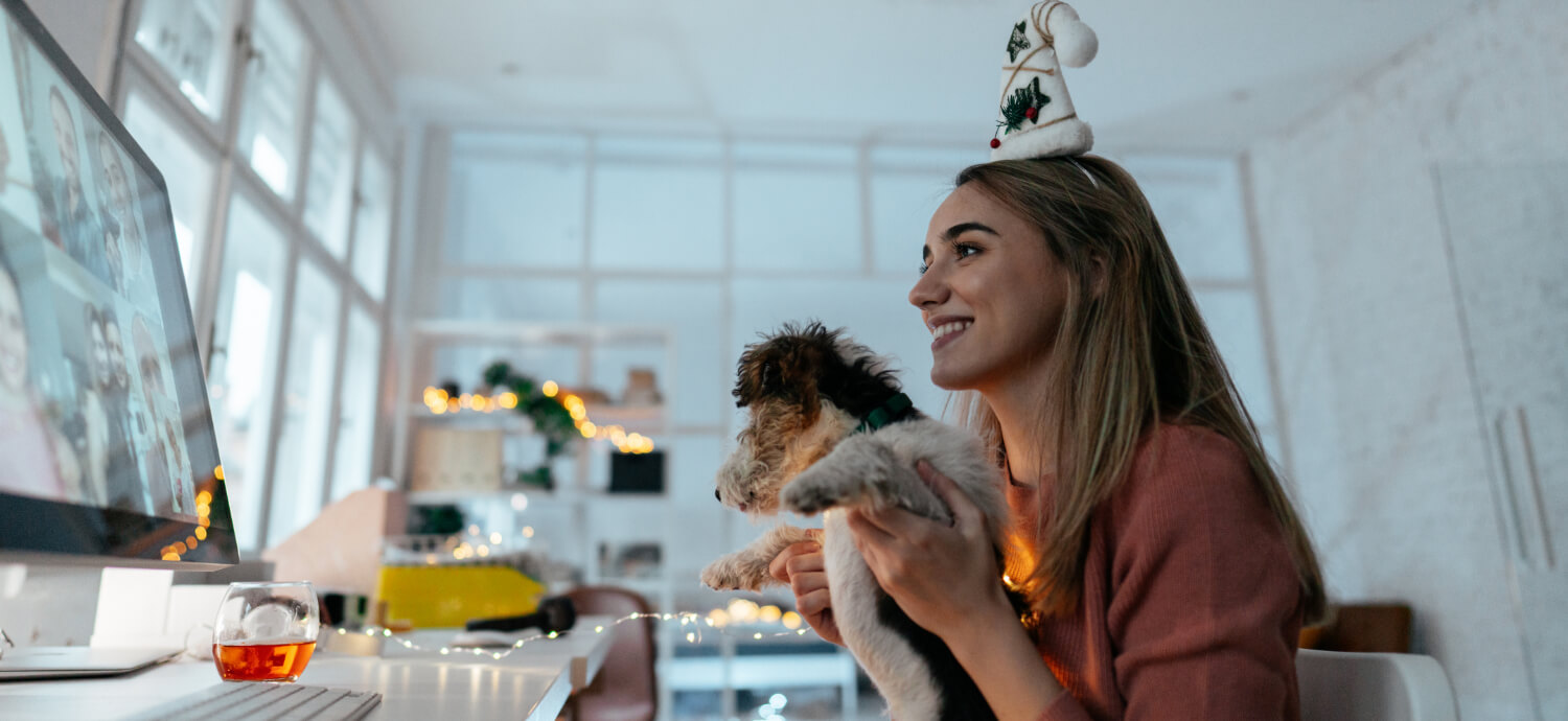 woman having a virtual holiday party with her dog