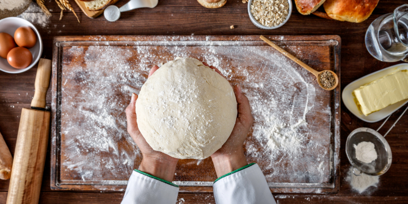 Soy lecithin used as a dough conditioner. Hands holding a loaf of bread dough