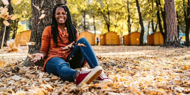 7 Popular Fall Supplement Staples Black woman playing in leaves